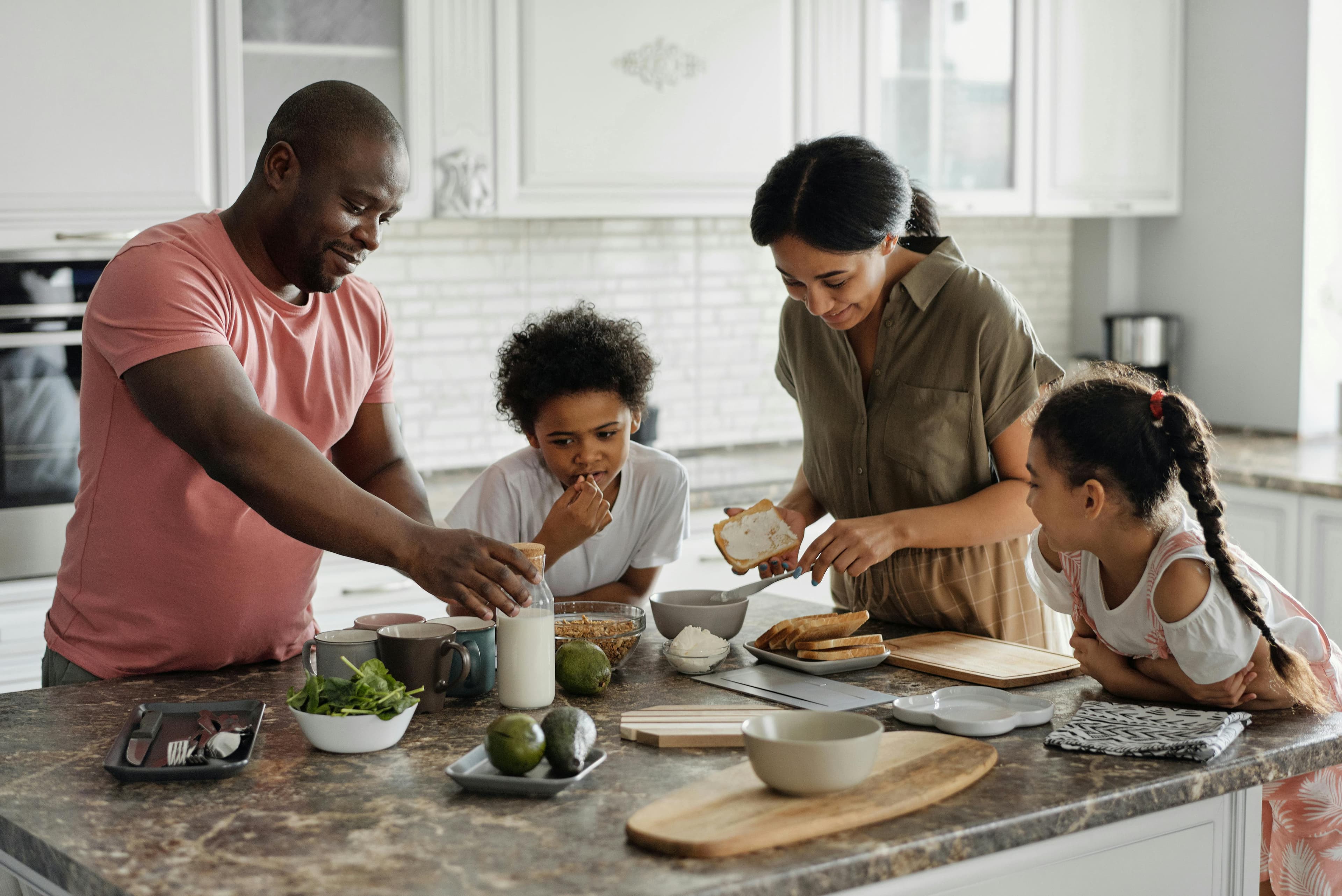 A family cooking together around a kitchen island